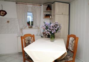 Una mesa blanca con un jarrón de flores. en Ferienwohnung Sonnenaufgang, en Penig