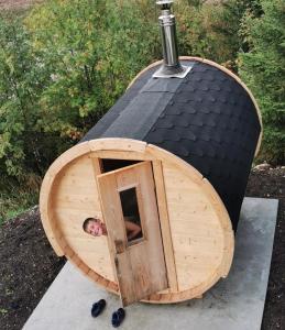 Ein Mann, der aus einem runden hölzernen Hundehaus schaut in der Unterkunft Chalet de charme avec terrasse, jardin et sauna extérieur in Chapelle-des-Bois