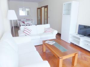 een woonkamer met een witte bank en een salontafel bij Apartamento luminoso, funcional y amplio en zona hospitalaria in Pamplona
