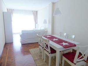 een witte eetkamer met een tafel en stoelen bij Apartamento luminoso, funcional y amplio en zona hospitalaria in Pamplona