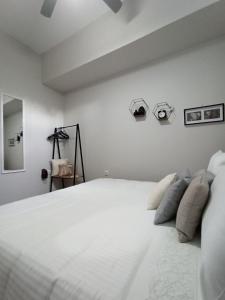 1 dormitorio con 1 cama con sábanas y almohadas blancas en Kallias Modern Seaview Apartment en Heraclión