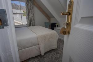 um quarto com uma cama e uma janela em Riverside Country House em Swellendam