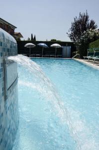 a large swimming pool with a water fountain at Hotel Smeraldo in Lazise