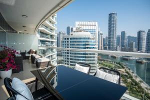 a balcony with a blue table and chairs and a city at WSuites - Big Terrace with Beautiful Marina View in Dubai