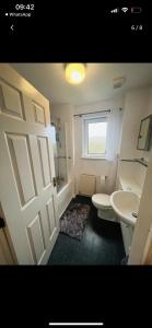 a bathroom with a toilet and a sink and a door at Lovely entire 2 Bedroom apartment in Monifieth