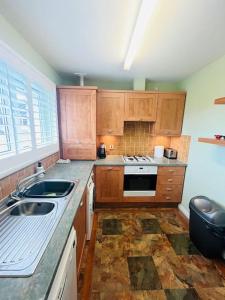 a kitchen with wooden cabinets and a stove top oven at Lovely entire 2 Bedroom apartment in Monifieth