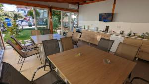 a room with tables and chairs and a kitchen at GreenCity Kavala in Kavála