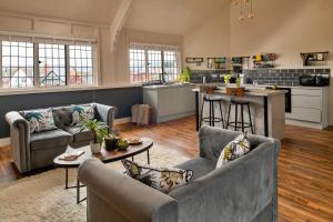 a living room with two couches and a kitchen at Finest Retreats - Sunnycroft Penthouse in Llandrindod Wells