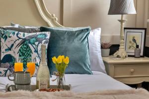 uma cama com almofadas azuis e uma mesa com flores em Finest Retreats - Sunnycroft Penthouse em Llandrindod Wells