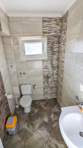 uma casa de banho com um WC, um lavatório e um chuveiro em GreenCity Kavala em Kavala