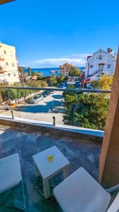 a balcony with two white chairs and a table at GreenCity Kavala in Kavála