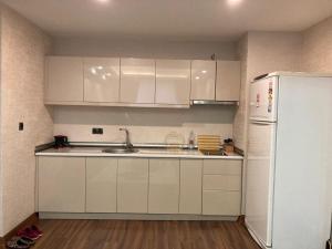 a kitchen with white cabinets and a white refrigerator at Aryan Suit. in Istanbul