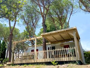 a house with a porch and a deck at Camping Village Mar y Sierra in San Costanzo