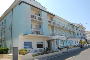 a blue building with people sitting outside of it at Hotel Alba D'Oro in Bellaria-Igea Marina