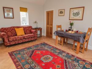 - un salon avec un canapé et une table avec un tapis dans l'établissement High Barns Cottage, à Morpeth