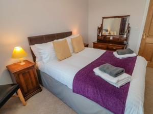 a bedroom with a large bed and a mirror at High Barns Cottage in Morpeth