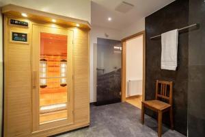 Łazienka z kabiną prysznicową i drewnianymi drzwiami w obiekcie Ferienwohnungen & Chalets Capricorno w mieście Mittelberg