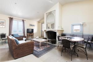 a living room with a fireplace and a table and chairs at Appartement Neptune in Saint-Martin-de-Ré