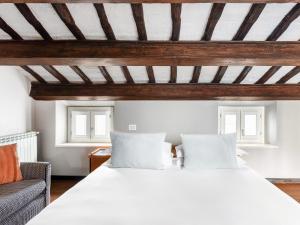 sypialnia z białym łóżkiem i 2 oknami w obiekcie numa I Vici Rooms & Apartments w Rzymie