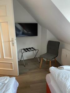 Zimmer mit einem Stuhl, einem Bett und einem Fenster in der Unterkunft H&H Apartment im Herzen von Greifswald Zentral in der Langen Reihe in Greifswald