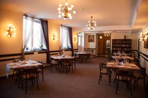 un comedor con mesas, sillas y ventanas en Florentina Hotel, en Edineţ