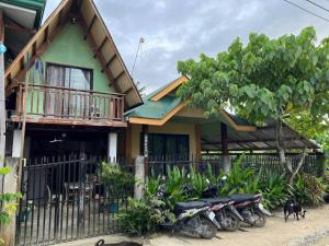 a house with motorcycles parked in front of it at Flo Island Home in General Luna