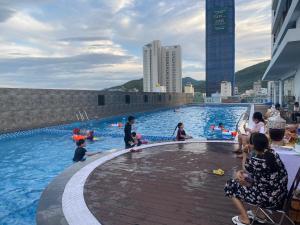 a group of people playing in a swimming pool at Tony Apartment -FLC Sea Tower Quy Nhon in Quy Nhon