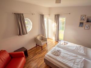 ein Schlafzimmer mit einem Bett, einem Stuhl und einem Fenster in der Unterkunft Marina Eldenburg - Ferienhäuser und Bootsverleih am Tor zur Müritz in Waren (Müritz)