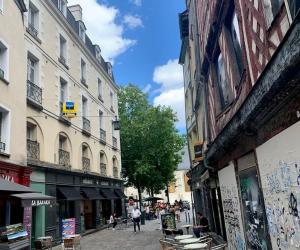 ulica z budynkami i ludźmi idącymi ulicą w obiekcie Studio cosy en plein centre historique de Rennes w mieście Rennes