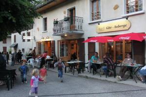 eine Gruppe von Kindern, die eine Straße vor einem Gebäude entlang gehen in der Unterkunft GITE AUBERGE L'HERBE TENDRE in Saint-Pierre-dʼEntremont