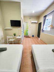 a hotel room with two beds and a television at Gurney Coast Guest House by Sky Hive in George Town