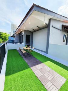 a patio with green grass and a table on a house at Gurney Coast Guest House by Sky Hive in George Town