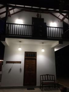 um edifício com uma escada, uma porta e um banco em Sweet Pea Homestay em Balapitiya