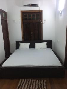 a bed with two pillows on it in a room at Sweet Pea Homestay in Balapitiya