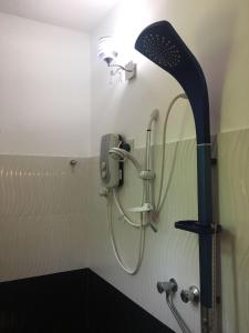 a shower in a bathroom with a shower head at Sweet Pea Homestay in Balapitiya