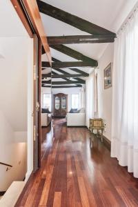 un ampio soggiorno con pavimenti in legno e una grande finestra di San Marco Bell Tower House a Venezia
