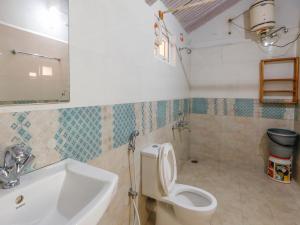 La salle de bains est pourvue de toilettes et d'un lavabo. dans l'établissement DEVASHOLA HOMESTAY, à Coonoor