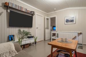 salon z telewizorem i stołem w obiekcie Lofoten- Fishermans logde with the view w mieście Stamsund