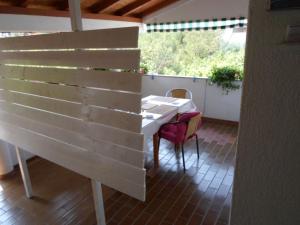 a table and chairs on a patio with a wooden wall at Studio apartman Kata Nin in Nin