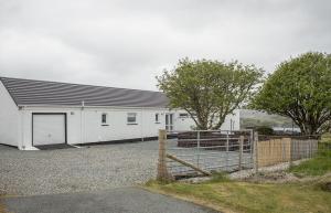 a white building with a gate and a fence at 8 Kildonan in Flashader