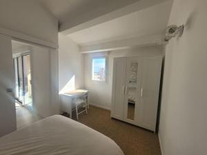 een slaapkamer met een bed, een bureau en een raam bij Béréa - Les Cormorans - Vue port et mer in Frontignan