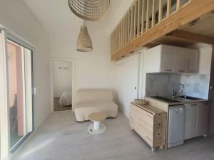 een kamer met een keuken met een wastafel en een tafel bij Béréa - Les Cormorans - Vue port et mer in Frontignan
