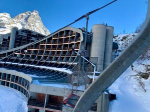 a building with a staircase in front of a mountain at Cervinia Ski In Ski Out - Family Studio in Breuil-Cervinia