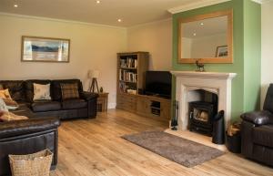 uma sala de estar com um sofá e uma lareira em Strath Glebe em Kilbride