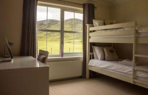 a bedroom with two bunk beds and a window at Strath Glebe in Kilbride