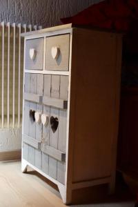 a wooden dresser with three cups in it at La Casa Suites Albaredo di Rotzo 