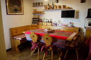 a kitchen with a table with a red table cloth on it at La Casa Suites Albaredo di Rotzo 