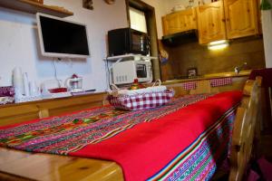 a kitchen with a table with a red blanket at La Casa Suites Albaredo di Rotzo 