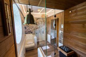 Una ducha de cristal en una habitación con banco y lámpara. en Hotel Willa Lubicz en Gdynia