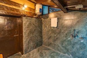 a bathroom with a shower with a sink at Zostel Homes Laida (Jibhi) in Sainj